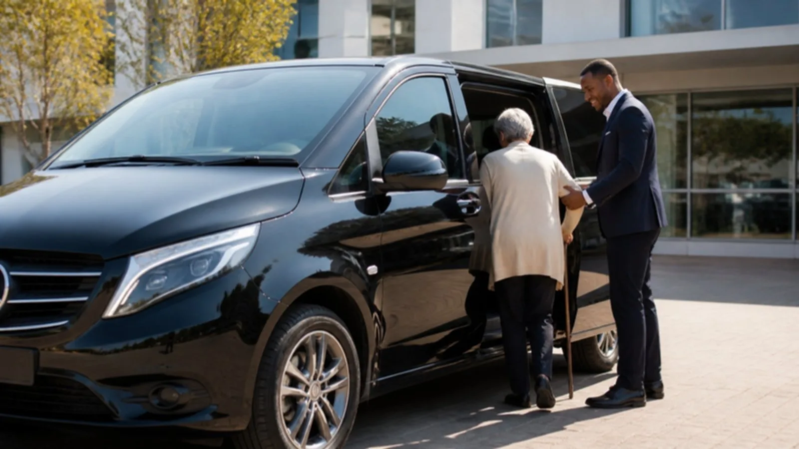 FundaDrive chauffeur helping a passenger into a black Mercedes Vito